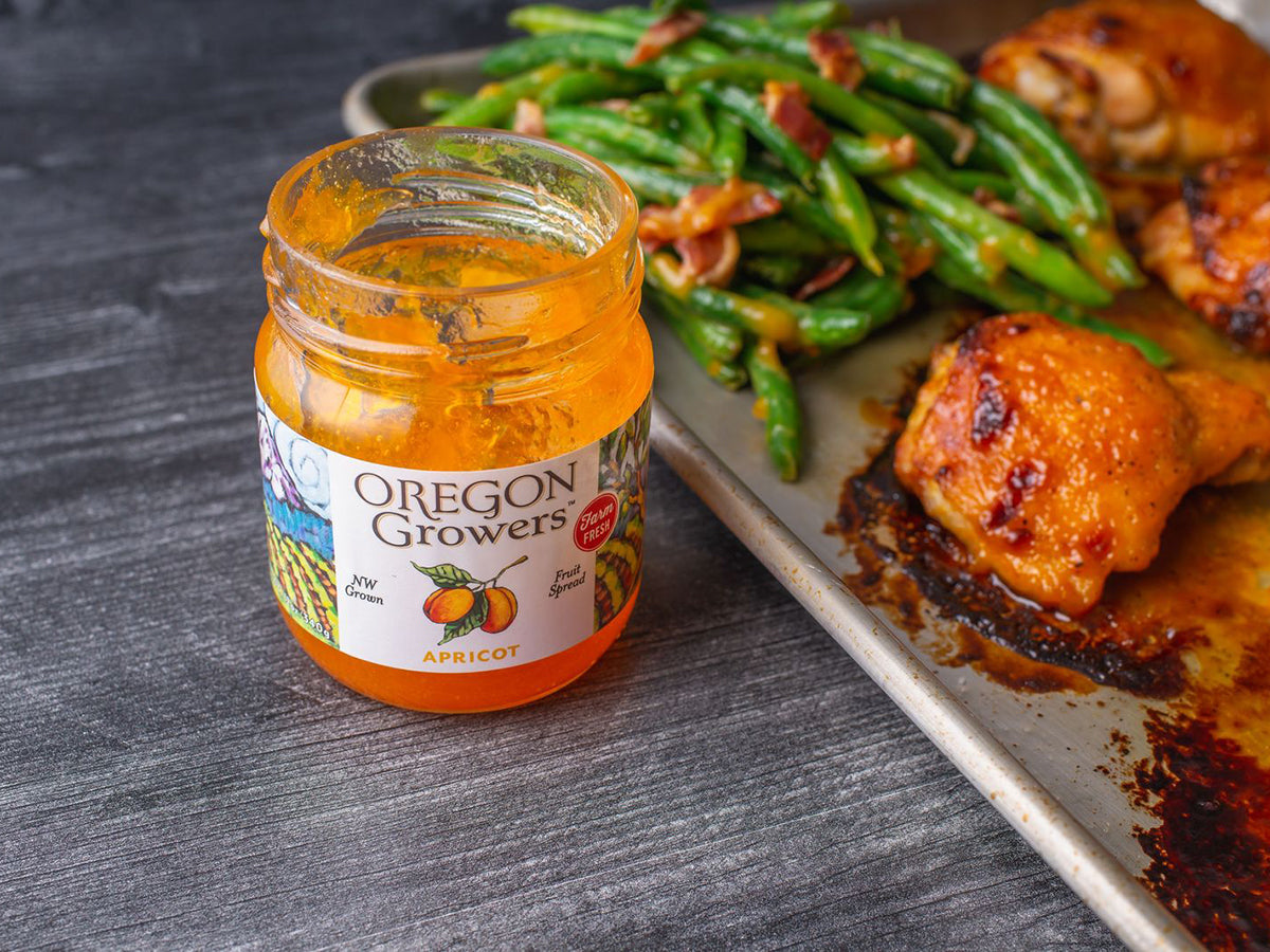 Crispy baked chicken thighs glazed with Oregon Grower's Apricot Jam. Served on a serving pan with green beans.