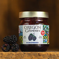 A close-up view of our Marionberry jam sitting next to some fresh marionberries.