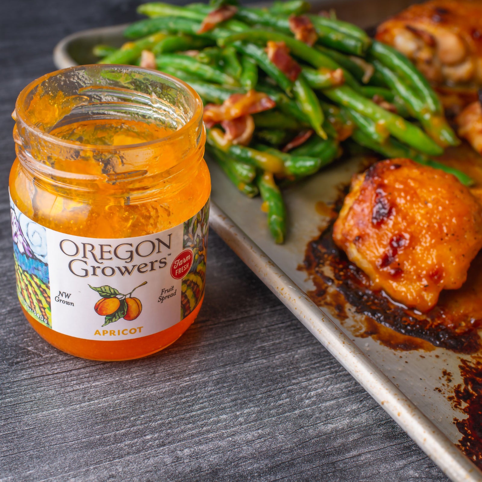 Close-up of Apricot Jam on a table next to a tin of glazed chicken.