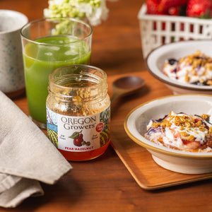 Close-up of Our Pear Hazelnut Jam on a breakfast table with bowls of yogurt.