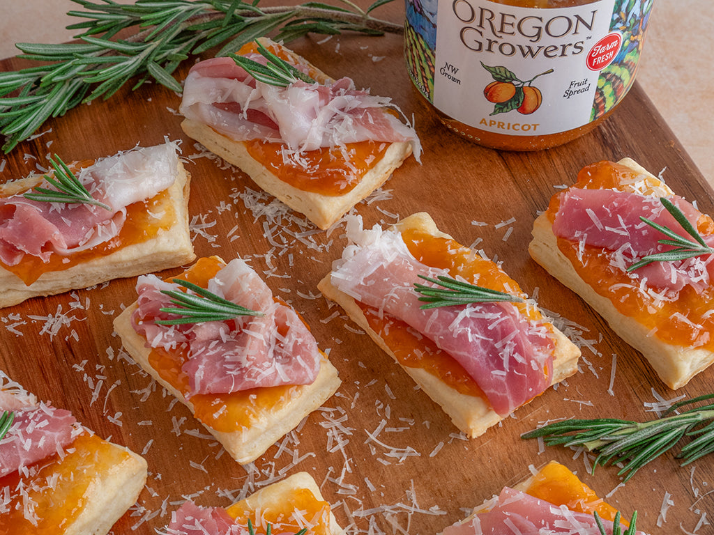 Apricot & Prosciutto Biscuit Bites served on a platter with finely shredded parmesan cheese and a spring of rosemary.