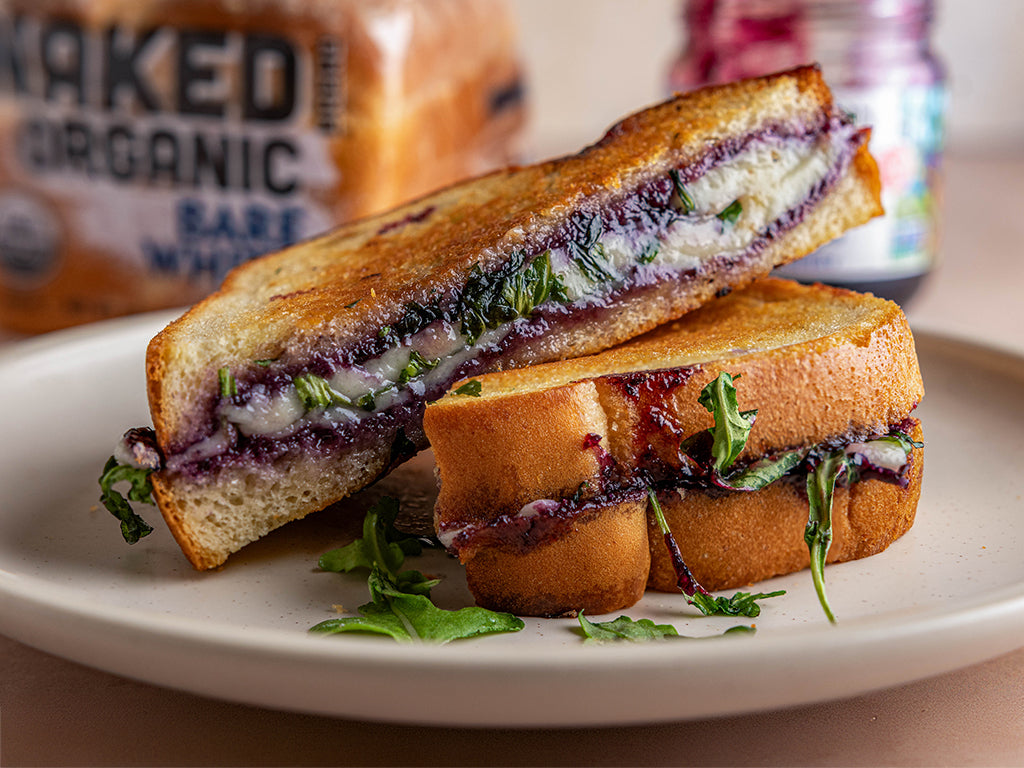 Sideview of a plate containing a Blueberry Grilled Cheese sandwich and an open jar of Oregon Growers Blueberry behind.