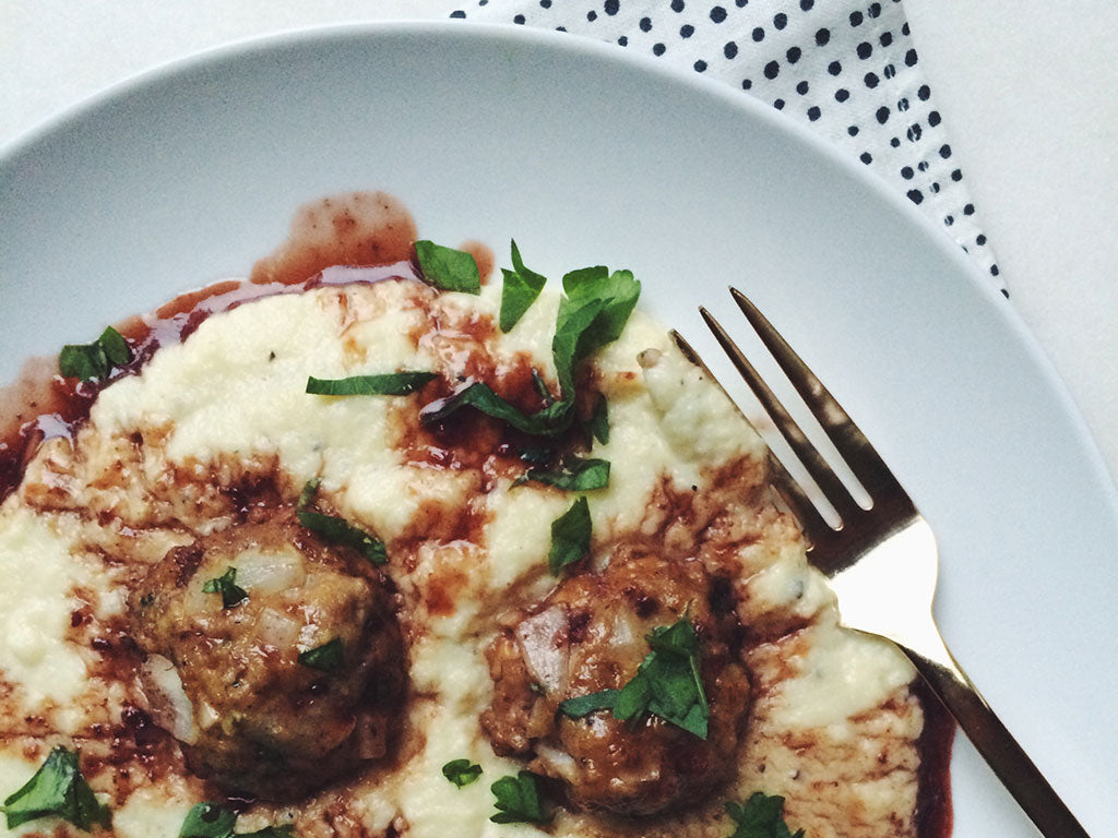 Plate of pureed parsnips topped with glazed meatballs using Oregon Growers Marionberry Jam and garnished with parsley.