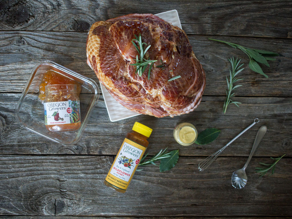 A table setting of glazed ham, viewed from top, and baked using Oregon Growers Pear Hazelnut Jam and Wildflower Honey. 