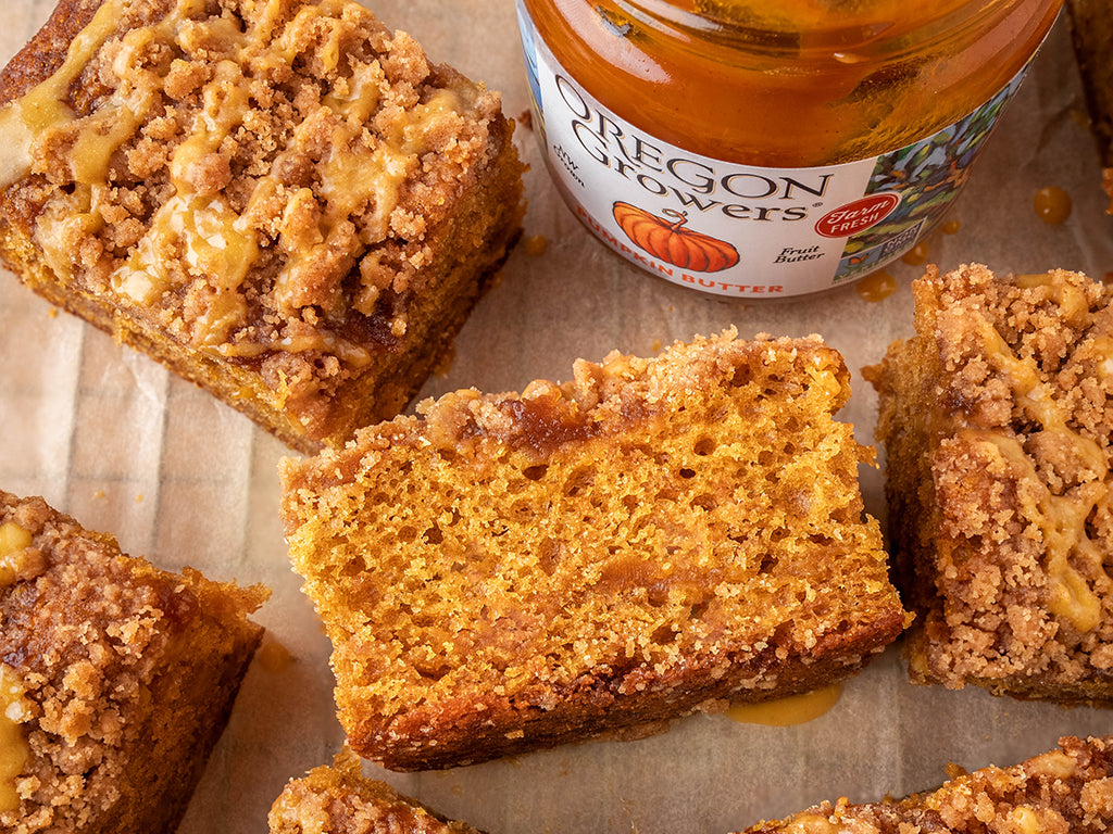 Top view of a table with squares of coffee cakes and a jar Oregon Growers Pumpkin Butter.