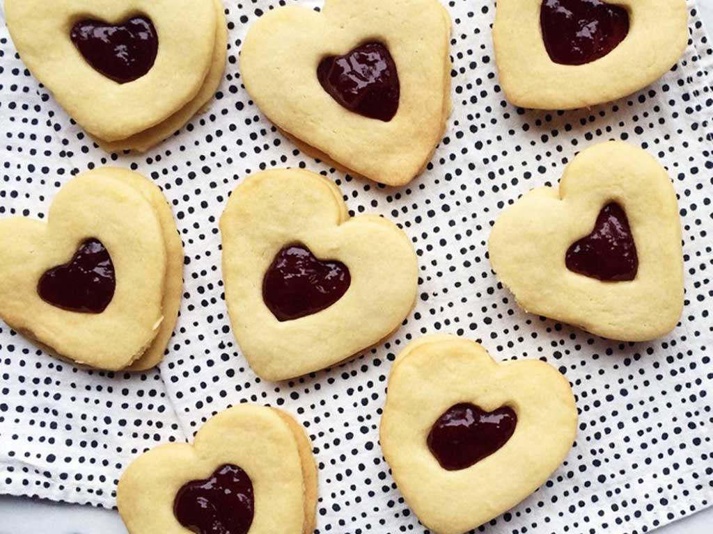 Plate of heart shaped cookies filled with Strawberry Pinot Noir Jam from Oregon Growers and made with sugar and vanilla.