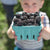 A boy holding a pint of freshly picked marionberries.