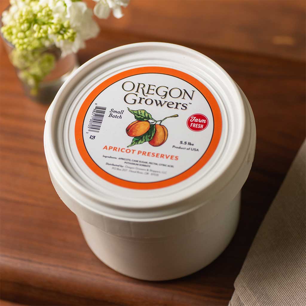 A close-up of a white 5.5 pound wholesale container for Apricot Preserves.