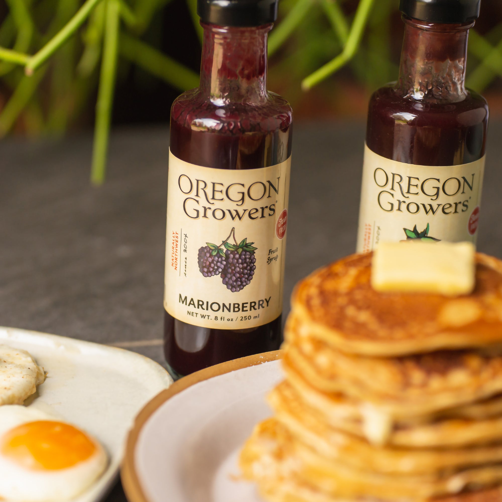  A Stack of pancakes covered with Marionberry Fruit Syrup .