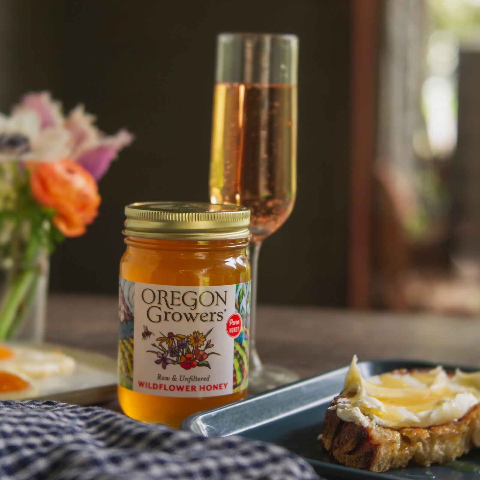 Close-up of our 18 oz Northwest Wildflower Honey jar on a breakfast table.