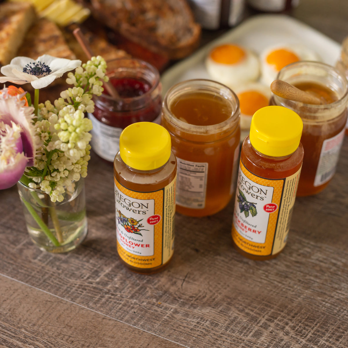 All four of Oregon Growers honey containers on a breakfast table.